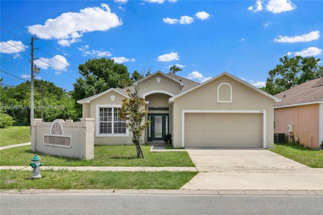 7974 Niagara Falls Ct, Orlando, FL 32825 - view of front of property with stucco siding, an attached garage, driveway, and a front lawn