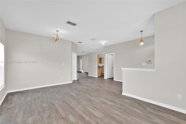 7974 Niagara Falls Ct, Orlando, FL 32825 - unfurnished living room featuring wood finished floors, a chandelier, and baseboards