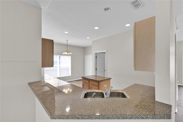 7974 Niagara Falls Ct, Orlando, FL 32825 - kitchen featuring a sink, recessed lighting, a chandelier, hanging light fixtures, and a peninsula