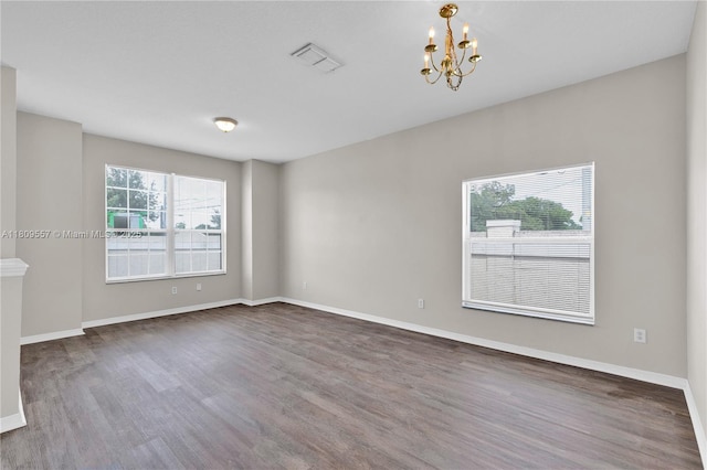 7974 Niagara Falls Ct, Orlando, FL 32825 - unfurnished room featuring wood finished floors, a chandelier, and baseboards