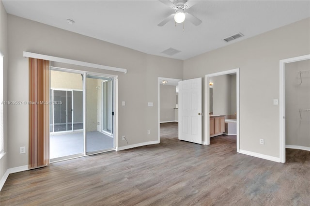 7974 Niagara Falls Ct, Orlando, FL 32825 - unfurnished bedroom with access to exterior, wood finished floors, a walk in closet, and ensuite bathroom