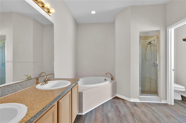 7974 Niagara Falls Ct, Orlando, FL 32825 - bathroom with toilet, wood finished floors, a bath, a shower stall, and double vanity