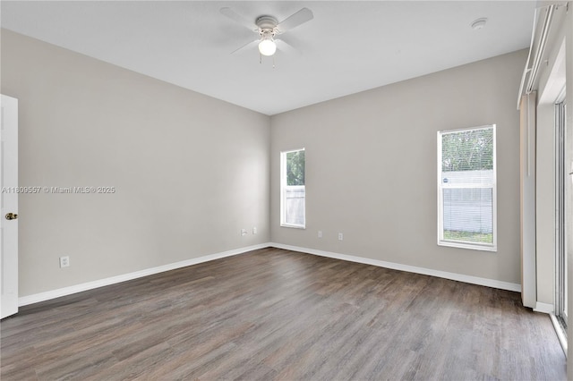 7974 Niagara Falls Ct, Orlando, FL 32825 - unfurnished room featuring a ceiling fan, healthy amount of natural light, dark wood finished floors, and baseboards