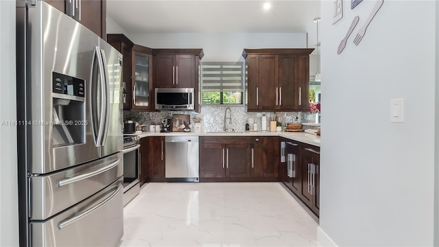 19120 SW 127th Pl, Miami, FL 33177 - kitchen featuring appliances with stainless steel finishes, a sink, light marble finish floors, backsplash, and light countertops