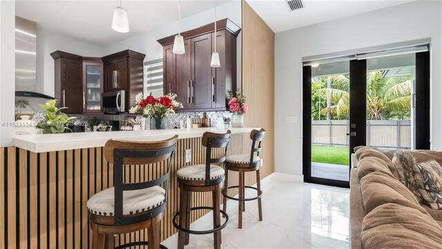 19120 SW 127th Pl, Miami, FL 33177 - bar with stainless steel microwave, decorative backsplash, decorative light fixtures, wall chimney exhaust hood, and light marble finish flooring