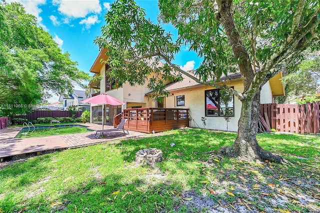 863 W Coco Plum Cir, Plantation, FL 33324 - back of house with stucco siding, a wooden deck, an outdoor fire pit, and a patio area