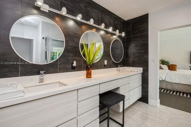 7625 SW 108th Ter, Pinecrest, FL 33156 - ensuite bathroom featuring tile walls, double vanity, and marble finish floors