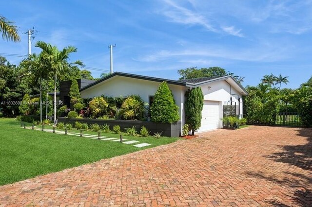 7625 SW 108th Ter, Pinecrest, FL 33156 - view of side of property featuring stucco siding, decorative driveway, and an attached garage