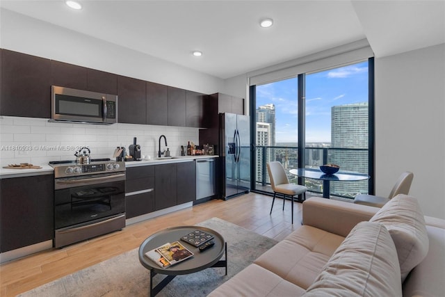 398 NE 5th St Unit 3803, Miami, FL 33132 - kitchen with appliances with stainless steel finishes, tasteful backsplash, light wood-type flooring, light countertops, and expansive windows