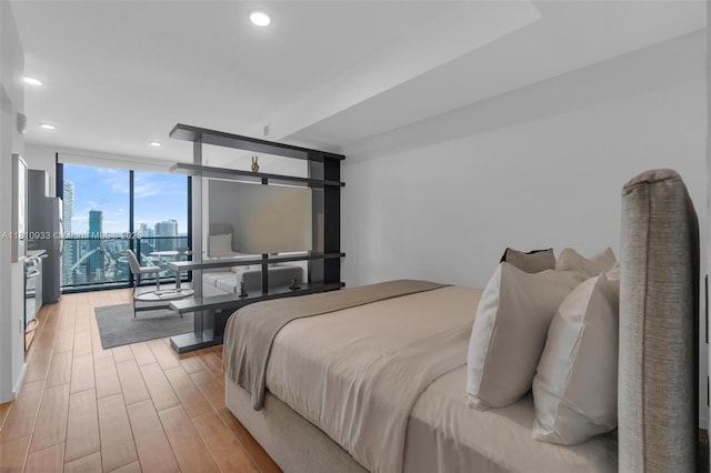398 NE 5th St Unit 3803, Miami, FL 33132 - bedroom with expansive windows, a skyline view, light wood-style floors, and recessed lighting