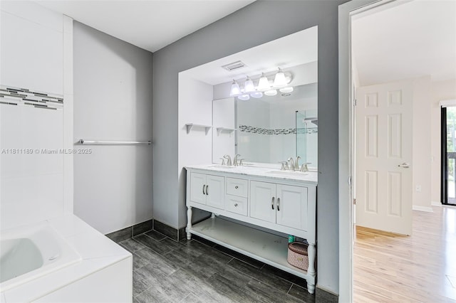 6967 SW 115th Pl Unit B34, Miami, FL 33173 - bathroom featuring double vanity, wood finished floors, a garden tub, and baseboards