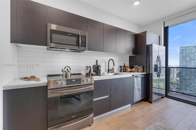 398 NE 5th St Unit 3503, Miami, FL 33132 - kitchen featuring stainless steel appliances, a wall of windows, a sink, light countertops, and backsplash