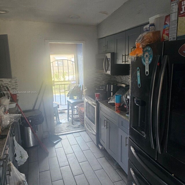 2211 Rutland St, Opa Locka, FL 33054 - kitchen with stainless steel appliances, backsplash, and gray cabinetry