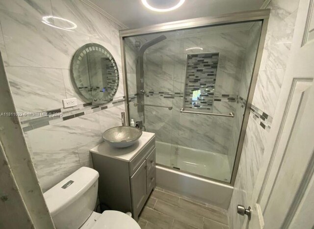 2211 Rutland St, Opa Locka, FL 33054 - full bath featuring vanity, toilet, combined bath / shower with glass door, and tile walls