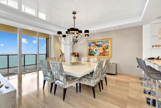 9701 Collins Ave Unit 2403S, Bal Harbour, FL 33154 - dining room with a chandelier, a tray ceiling, light wood finished floors, and expansive windows