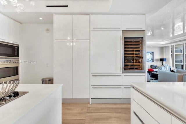 9701 Collins Ave Unit 2403S, Bal Harbour, FL 33154 - kitchen featuring built in microwave, modern cabinets, stainless steel oven, and white cabinets