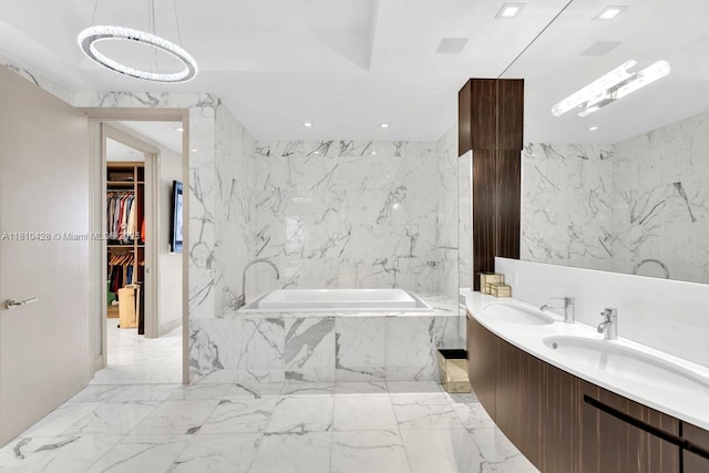 9701 Collins Ave Unit 2403S, Bal Harbour, FL 33154 - bathroom featuring a garden tub, marble tiled floors, a walk in closet, recessed lighting, and double vanity