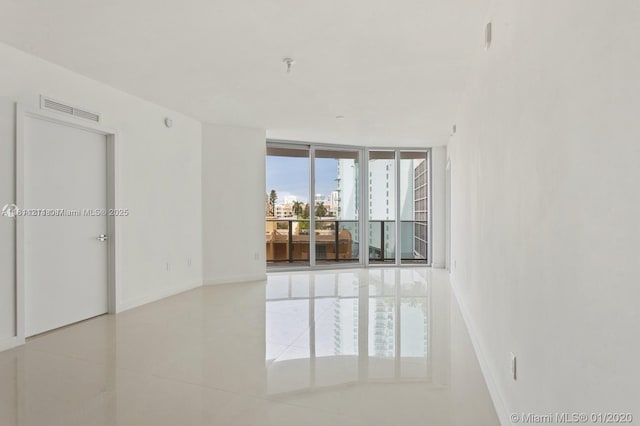 488 NE 18th St Unit 501, Miami, FL 33132 - empty room featuring baseboards, floor to ceiling windows, tile patterned flooring, a pendent fire sprinkler, and a city view
