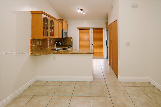 7191 W 24th Ave Unit 31-Ph7, Hialeah, FL 33016 - kitchen featuring stainless steel microwave, a sink, glass insert cabinets, stone countertops, and a peninsula