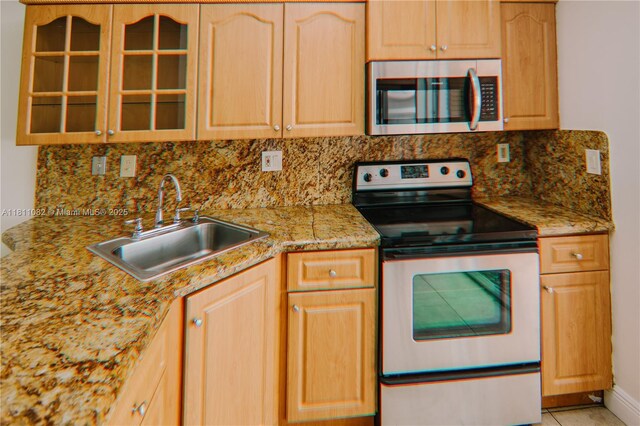7191 W 24th Ave Unit 31-Ph7, Hialeah, FL 33016 - kitchen featuring appliances with stainless steel finishes, a sink, glass insert cabinets, tasteful backsplash, and light brown cabinetry