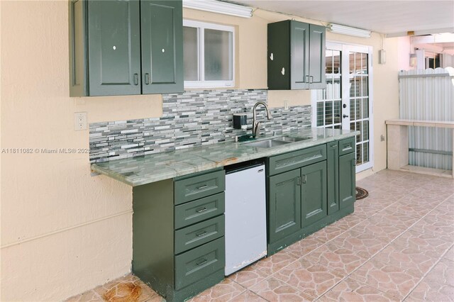 7191 W 24th Ave Unit 31-Ph7, Hialeah, FL 33016 - kitchen with green cabinetry, a sink, and decorative backsplash