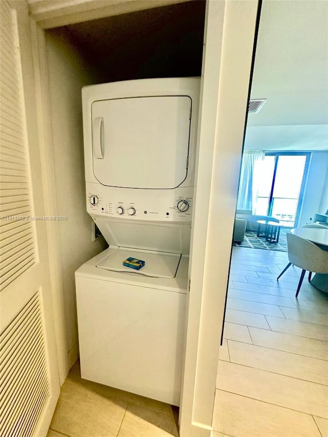 4010 S Ocean Dr Unit R1703, Hollywood, FL 33019 - washroom featuring stacked washer / dryer and light tile patterned floors