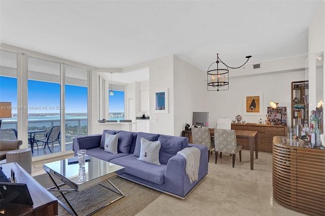 4779 Collins Ave Unit 4006, Miami Beach, FL 33140 - living area featuring a water view, a chandelier, and a wall of windows