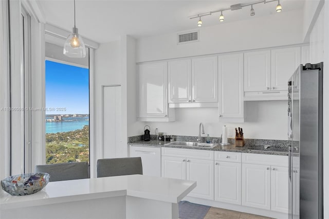 4779 Collins Ave Unit 4006, Miami Beach, FL 33140 - kitchen featuring a sink, freestanding refrigerator, under cabinet range hood, white cabinets, and black electric cooktop