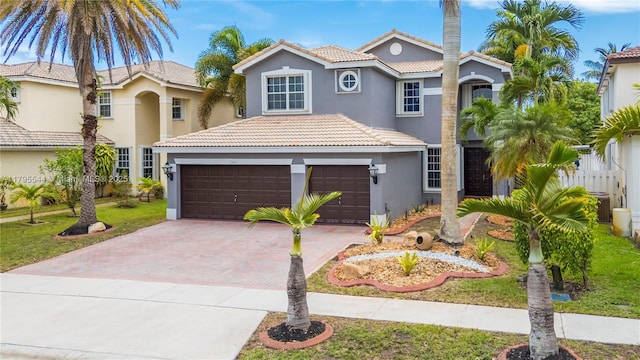 15862 SW 24th St, Miramar, FL 33027 - mediterranean / spanish-style home featuring stucco siding, a tiled roof, decorative driveway, an attached garage, and a front yard