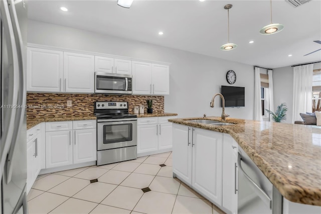 15862 SW 24th St, Miramar, FL 33027 - kitchen featuring stainless steel appliances, tasteful backsplash, white cabinetry, pendant lighting, and light stone counters