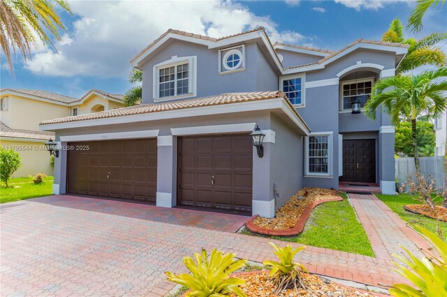 15862 SW 24th St, Miramar, FL 33027 - mediterranean / spanish house featuring stucco siding, decorative driveway, a tile roof, and an attached garage
