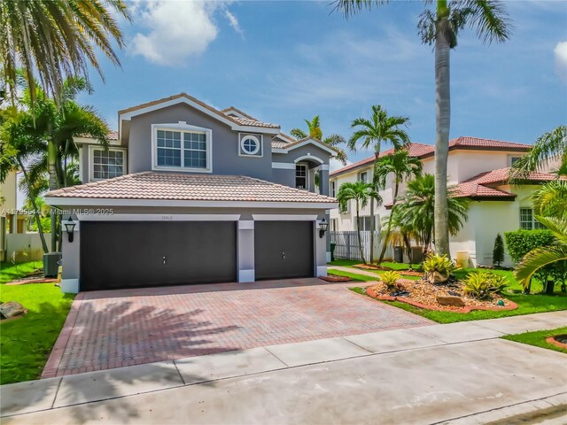 15862 SW 24th St, Miramar, FL 33027 - mediterranean / spanish house with stucco siding, decorative driveway, a tiled roof, and a garage