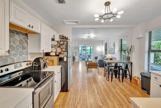 2763 NW 3rd St, Miami, FL 33125 - kitchen featuring stainless steel appliances, white cabinetry, light countertops, and healthy amount of natural light