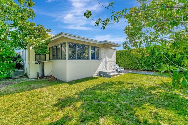 2763 NW 3rd St, Miami, FL 33125 - view of property exterior featuring stucco siding, a lawn, and central AC unit