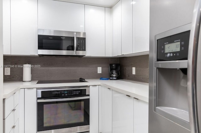 185 SE 14th Ter Unit 909, Miami, FL 33131 - kitchen featuring stainless steel appliances, modern cabinets, white cabinets, decorative backsplash, and light countertops