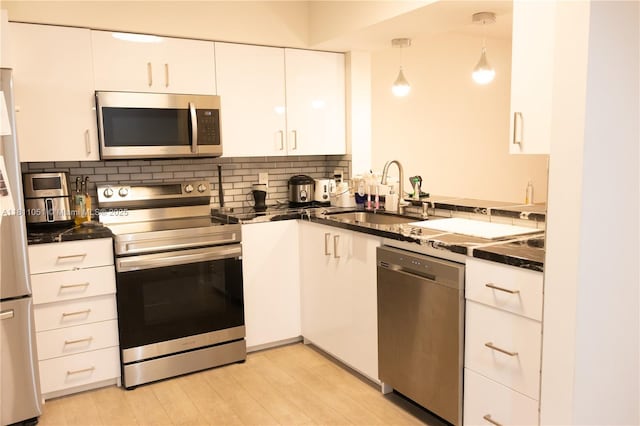 2200 S Cypress Bend Dr Unit 204, Pompano Beach, FL 33069 - kitchen featuring appliances with stainless steel finishes, a sink, dark countertops, and white cabinetry