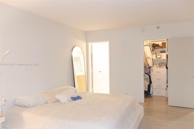 2200 S Cypress Bend Dr Unit 204, Pompano Beach, FL 33069 - bedroom featuring a walk in closet, light wood-type flooring, a closet, and ensuite bath