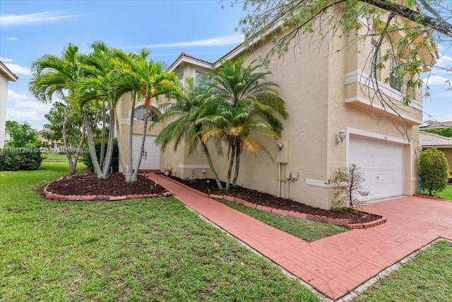 16466 SW 29th St, Miramar, FL 33027 - view of property exterior with stucco siding, a garage, a yard, and decorative driveway