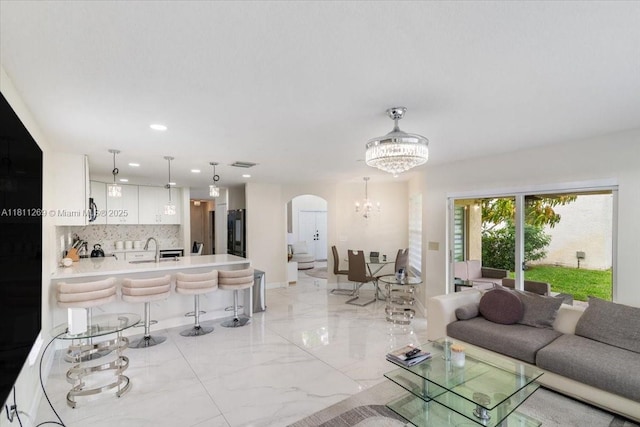 16466 SW 29th St, Miramar, FL 33027 - living area with arched walkways, a chandelier, light marble finish floors, and recessed lighting