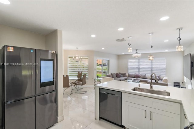 16466 SW 29th St, Miramar, FL 33027 - kitchen with stainless steel appliances, a sink, open floor plan, light marble finish floors, and white cabinetry