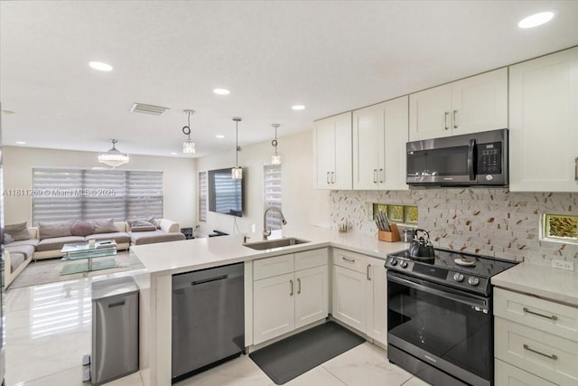 16466 SW 29th St, Miramar, FL 33027 - kitchen featuring appliances with stainless steel finishes, a sink, a peninsula, open floor plan, and white cabinets
