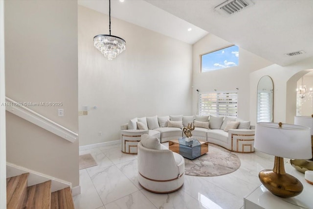 16466 SW 29th St, Miramar, FL 33027 - living area with a chandelier, marble look tiles, high vaulted ceiling, stairway, and arched walkways
