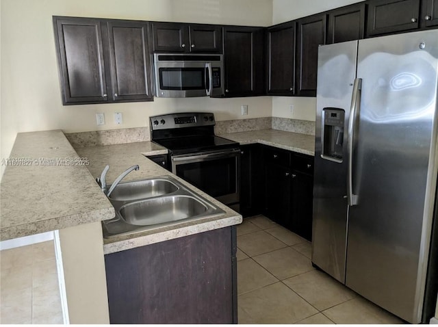 22411 SW 88th Pl Unit 9-26, Cutler Bay, FL 33190 - kitchen featuring stainless steel appliances, a sink, a peninsula, light tile patterned flooring, and light countertops