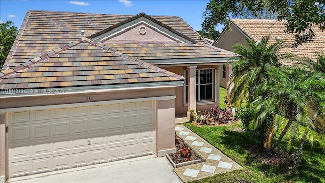 930 Briar Ridge Rd, Weston, FL 33327 - view of front of home with stucco siding, a tiled roof, concrete driveway, and an attached garage