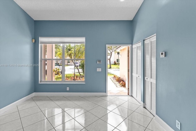 930 Briar Ridge Rd, Weston, FL 33327 - empty room featuring light tile patterned floors, baseboards, and a textured ceiling