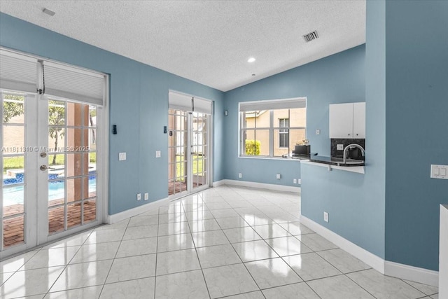 930 Briar Ridge Rd, Weston, FL 33327 - spare room with lofted ceiling, a textured ceiling, light tile patterned floors, baseboards, and a sink