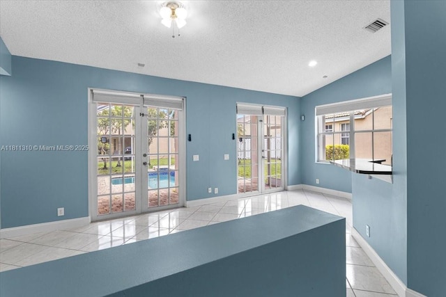 930 Briar Ridge Rd, Weston, FL 33327 - empty room featuring a textured ceiling, tile patterned flooring, french doors, lofted ceiling, and baseboards