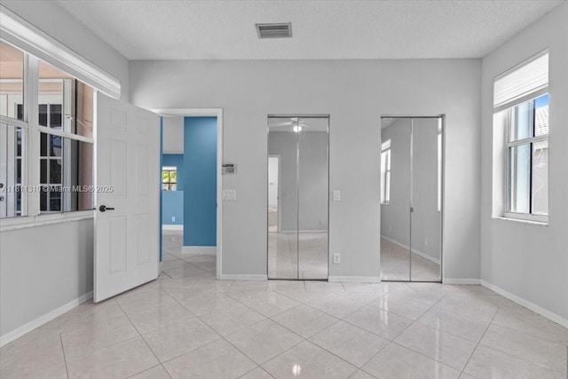 930 Briar Ridge Rd, Weston, FL 33327 - unfurnished bedroom with multiple windows, tile patterned floors, and a textured ceiling