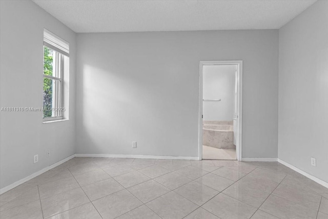 930 Briar Ridge Rd, Weston, FL 33327 - empty room featuring a textured ceiling, light tile patterned floors, and baseboards