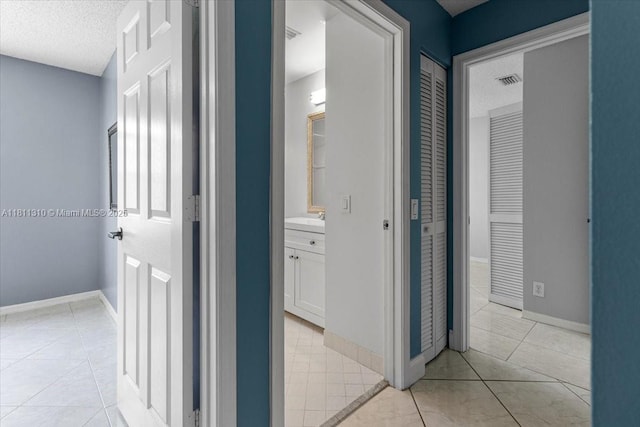 930 Briar Ridge Rd, Weston, FL 33327 - corridor featuring light tile patterned floors, a sink, a textured ceiling, and baseboards